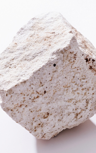 Una persona trabajando en una mina, lleva un chaleco amarillo y un casco blanco